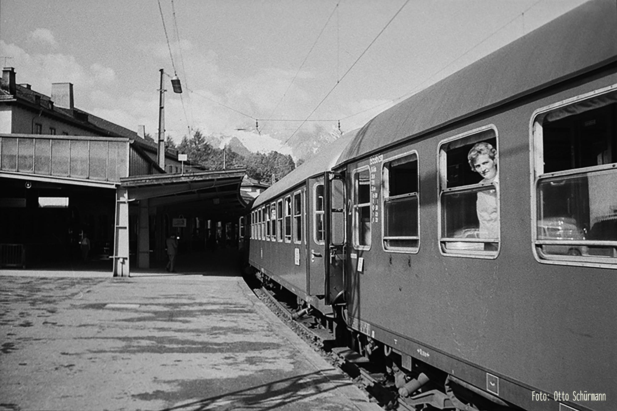 Das Foto zeigt den Bahnsteig des Bahnhofs Berchtesgaden. Rechts schaut eine Frau wehmütig aus einem geöffneten Wagenfenster. - Foto: Otto Schürmann - ca 1962